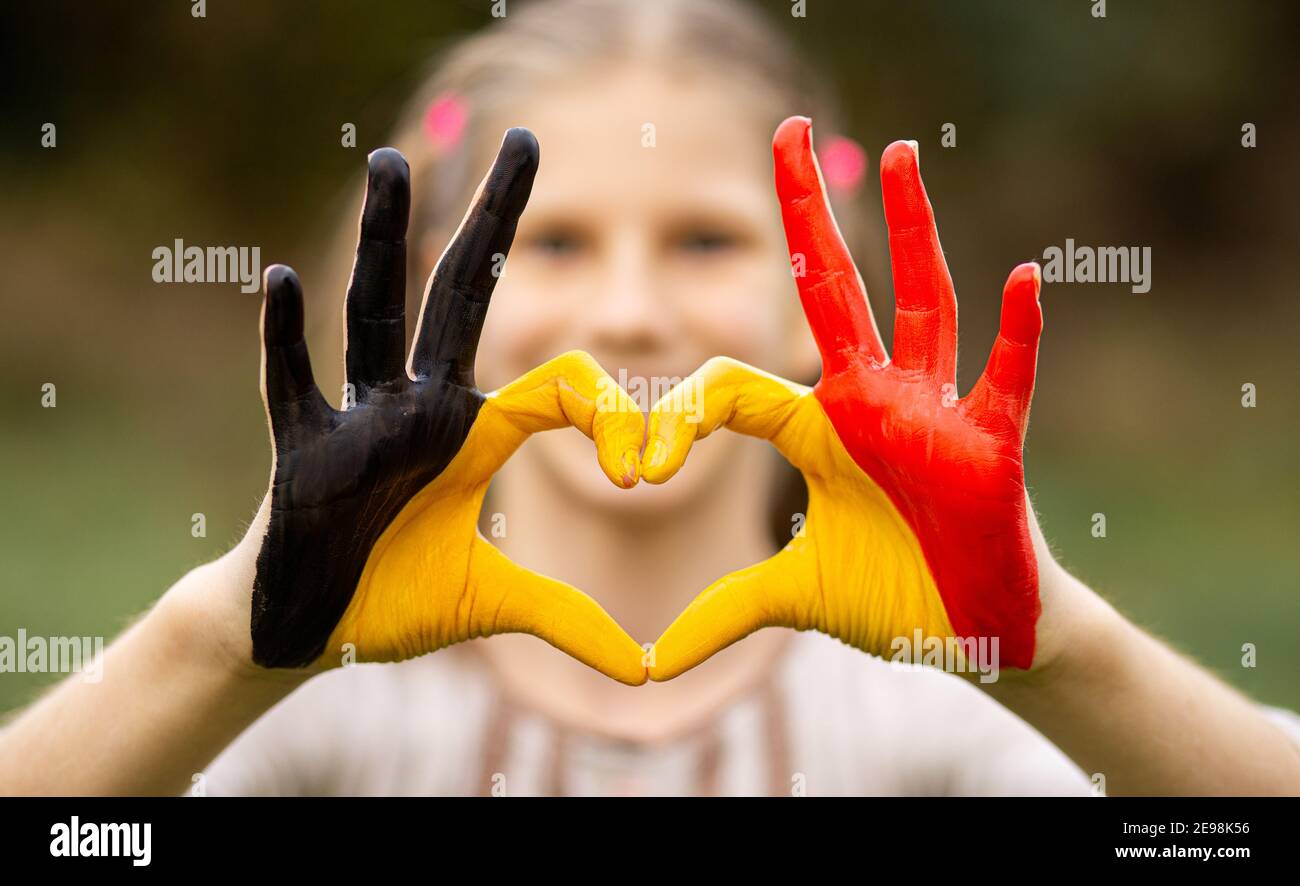 Kinder Hände in Belgien Flagge Farbe gemalt zeigen Symbol des Herzens und Liebe Geste auf Natur Hintergrund. Konzentrieren Sie sich auf die Hände Stockfoto