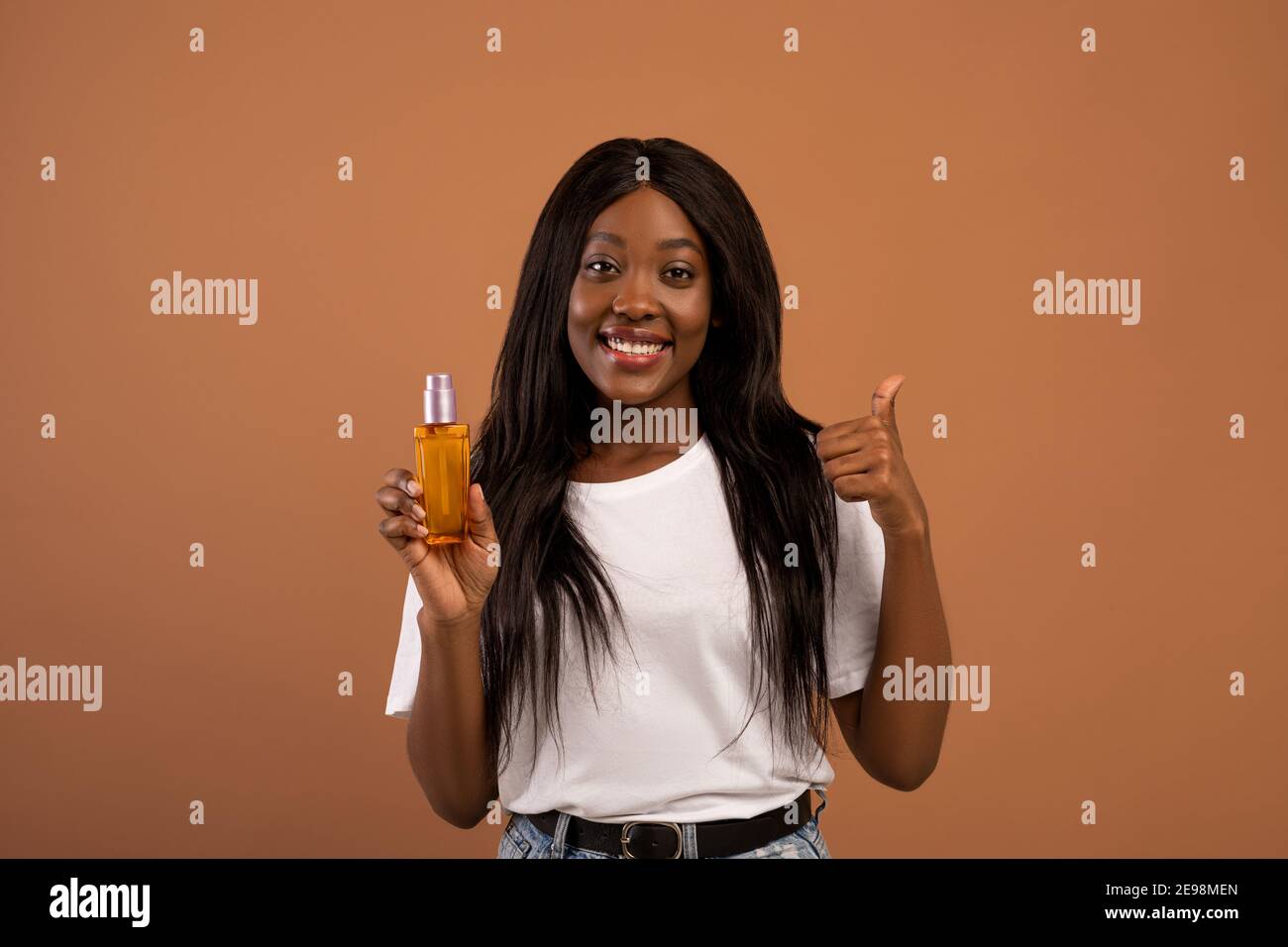 Hübsche schwarze Frau mit langen schönen Haaren empfehlen Haarprodukt Stockfoto