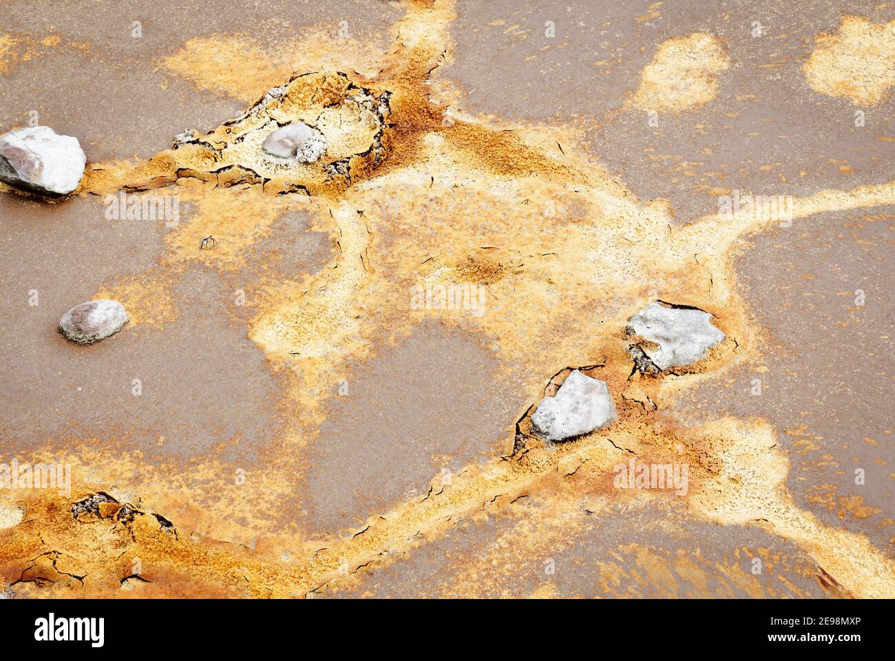 Abstrakte Texturen und Formationen am Ufer des Rio Tinto Flusses, Andalusien Spanien. Schattierungen von Rot und Orange, Eisen und andere Mineralien im Wasser. Stockfoto