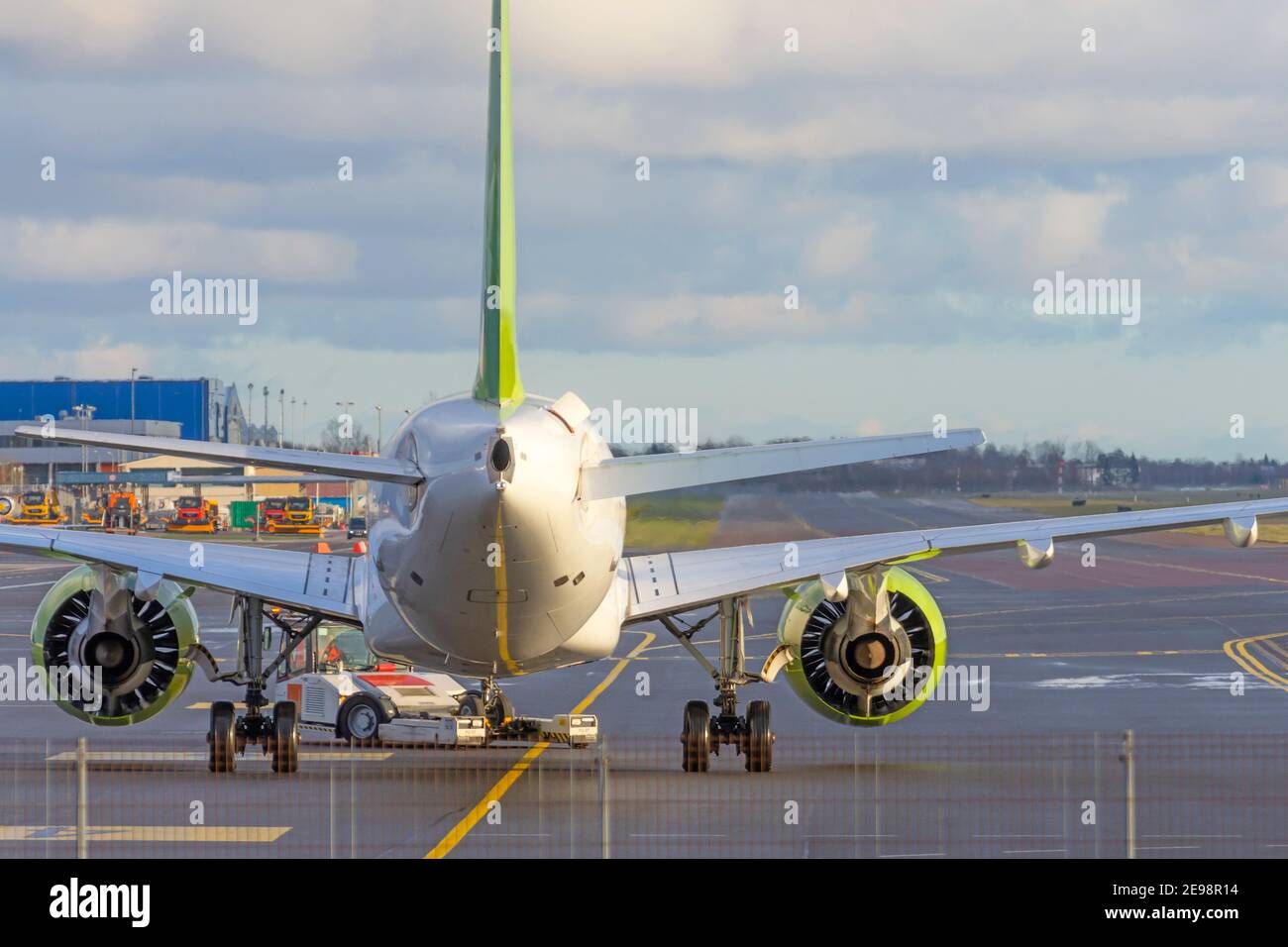 Das Flugzeug schiebt den Schlepper vor dem Starten der Motoren und Rollen, Rückansicht Stockfoto