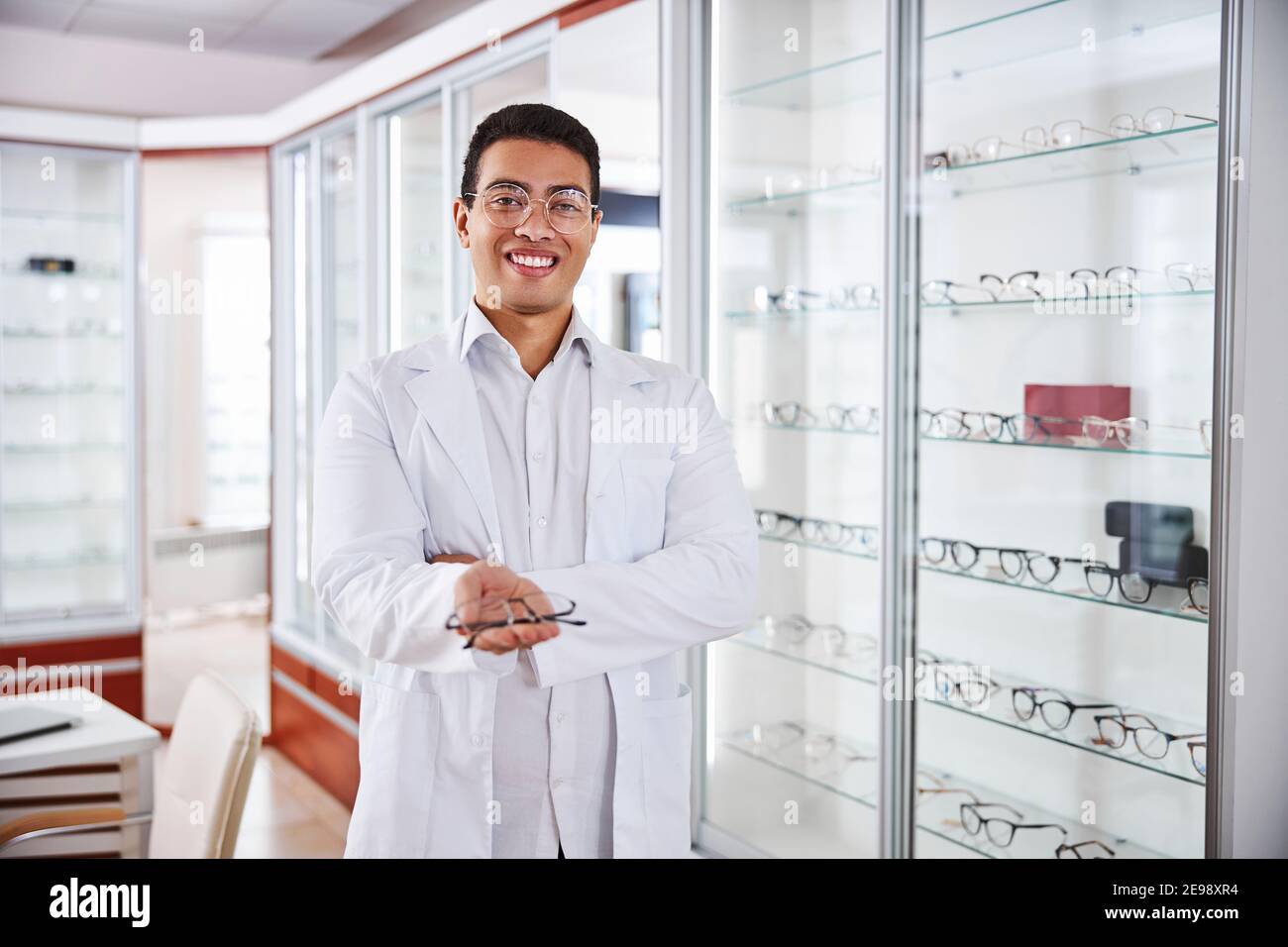 Lächelnder Optometrist bietet trendige Gläser für Kunden Stockfoto