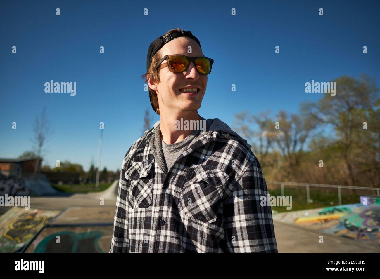 Junge kanadische Mann glücklich lächelnd in Skateboard Park Stockfoto