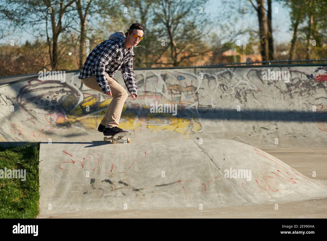 Männliche skateboard Gebläse um konkreten Rampe rollen im Skatepark Stockfoto