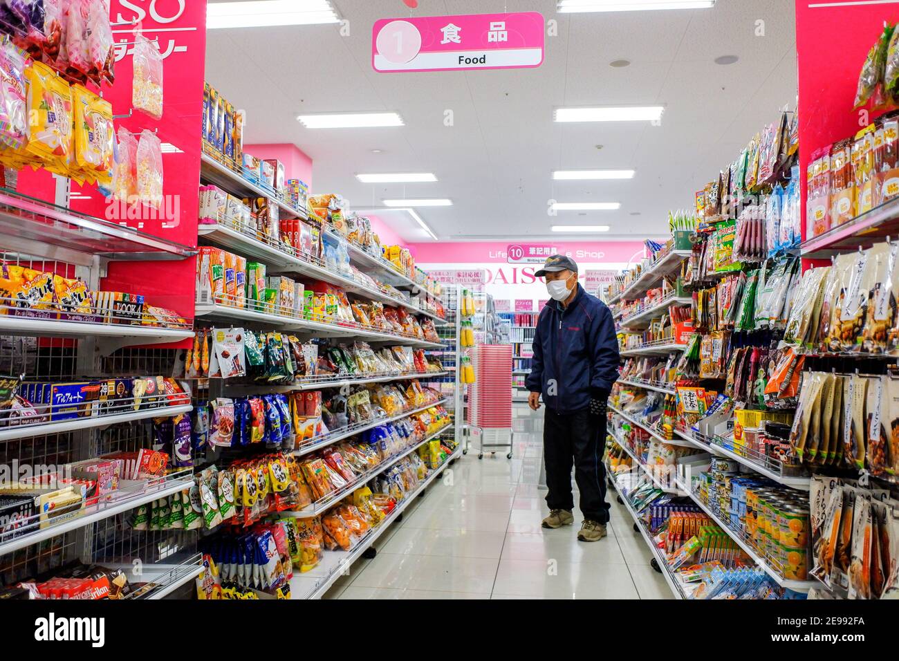 Ein Mann, der eine Gesichtsmask als vorbeugende Maßnahme gegen die Verbreitung von Coronavirus (COVID-19) Shops im Daiso 100 Yen Store in Tokio trägt. Daiso ist eine der größten 100 Yen-Shop-Ketten in Japan mit einer Auswahl von mehr als 100.000 Artikeln von Gartengeräten bis Telefonladegeräte für 100 Yen (ca. USD 1,00). Gesichtsmasken, Daiso Japan Fabrik in china macht 2 Millionen Stücke von chirurgischen Masken jeden Tag, Kindermasken sind auch verfügbar. Stockfoto