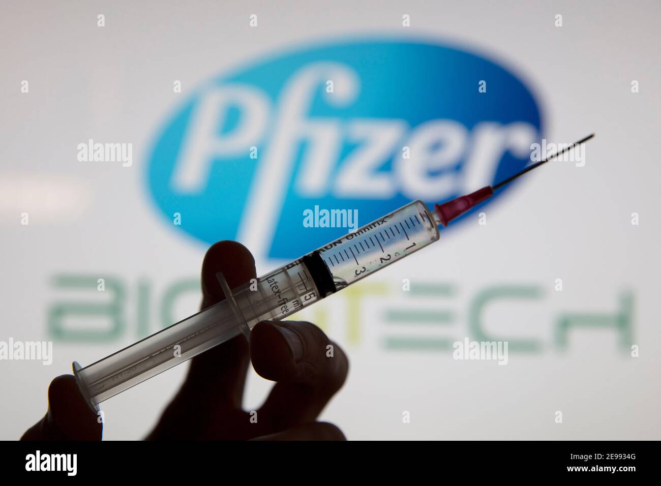 OXFORD, Großbritannien - Februar 2020: Eine kovidierte Impfstoffspritze vor dem pfizer-Logo Stockfoto