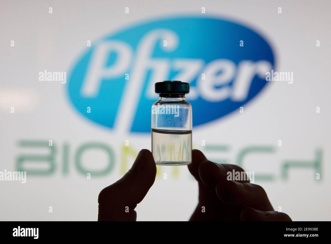 OXFORD, Großbritannien - Februar 2020: Eine kovidierte Impfstoffflasche vor dem pfizer-Logo Stockfoto