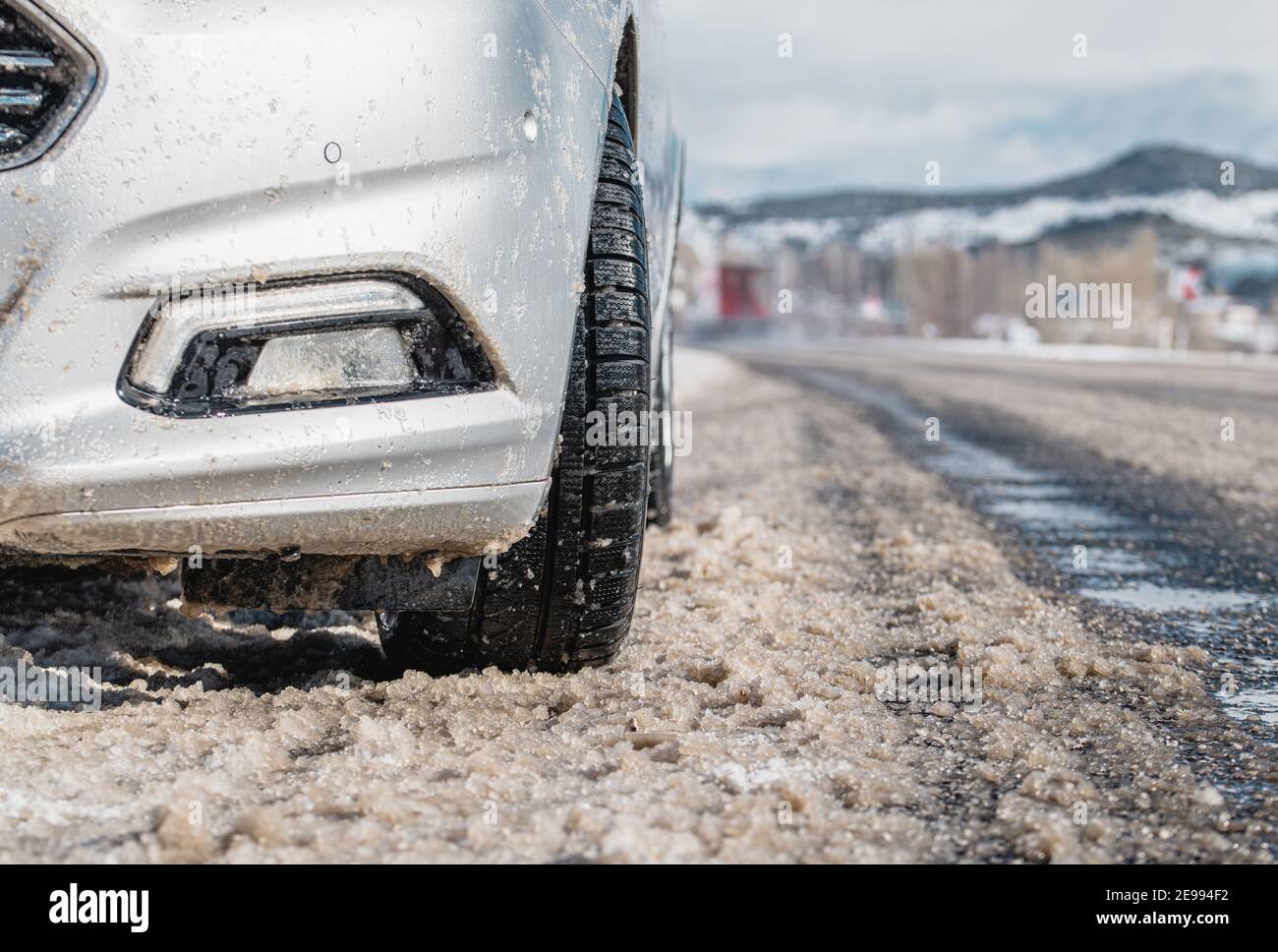Nahaufnahme der Autoreifen im Winter auf der schneebedeckten Straße. Selektiver Fokus Stockfoto
