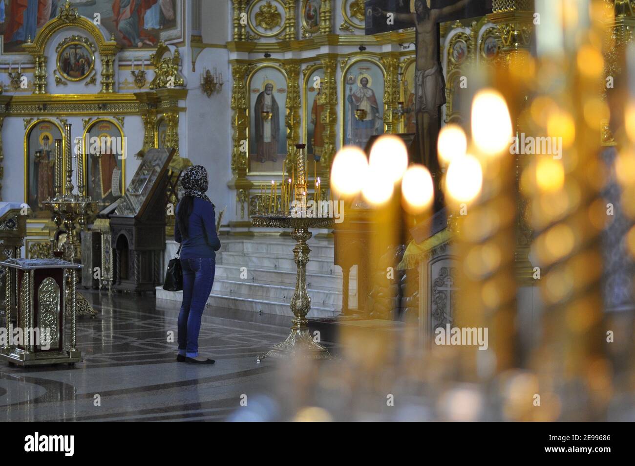 Eine Frau in einem Tempel. Das Innere der orthodoxen Kirche. Eine Person betet in einer Kirche. Stockfoto