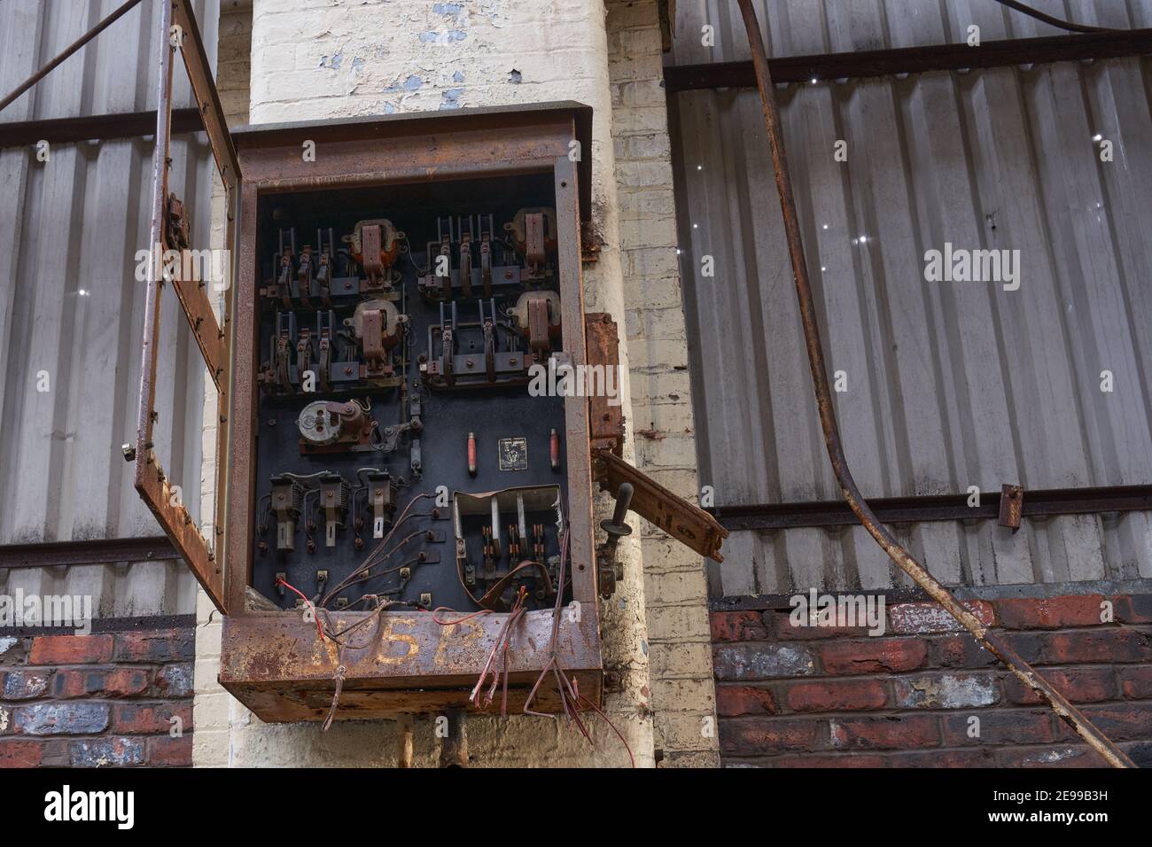 Ein alter elektrischer Verbraucherkasten in einer verlassenen Fabrik Stockfoto