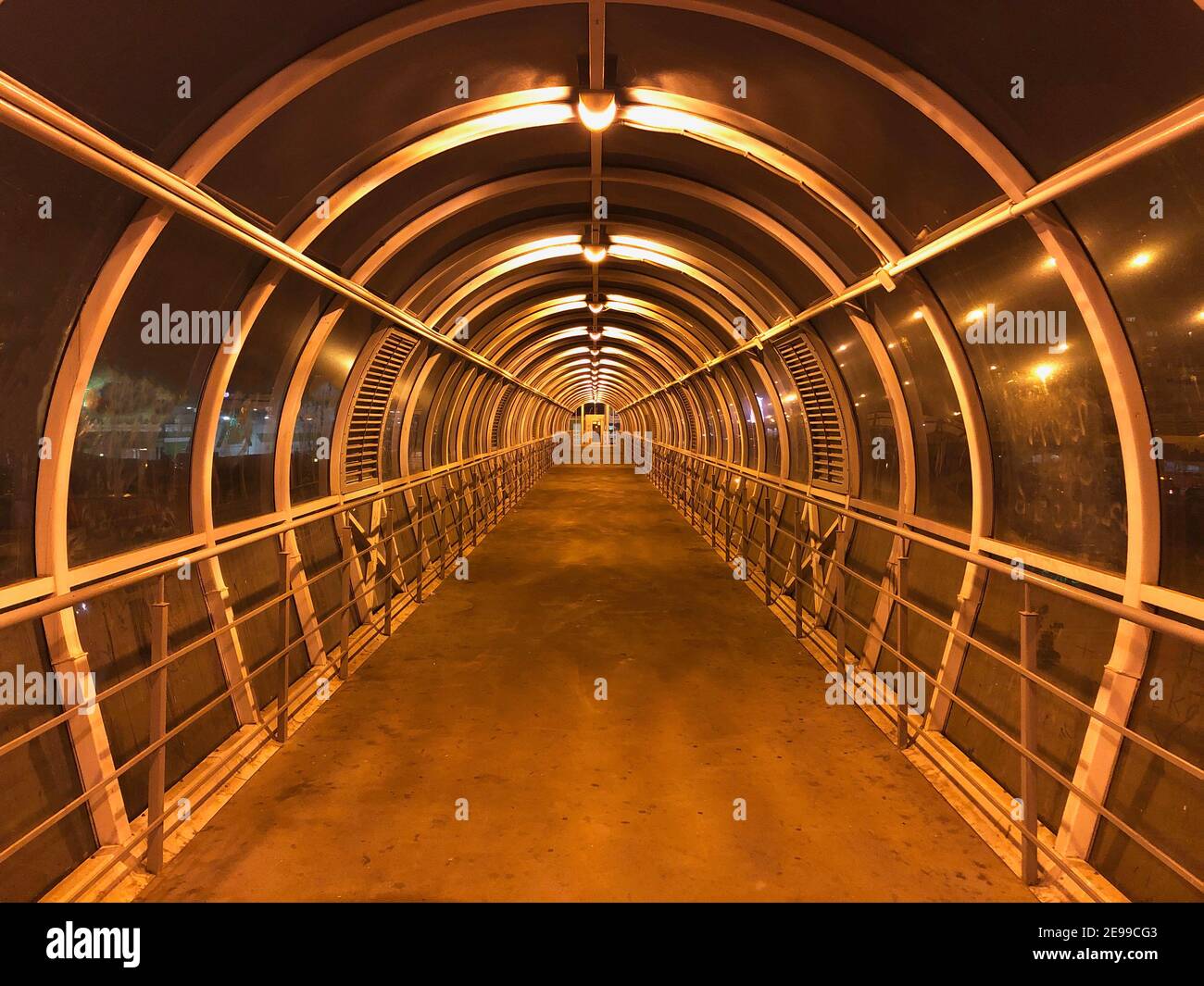 Runder Tunnel, der nachts in die Ferne führt. Symmetrie. Stockfoto