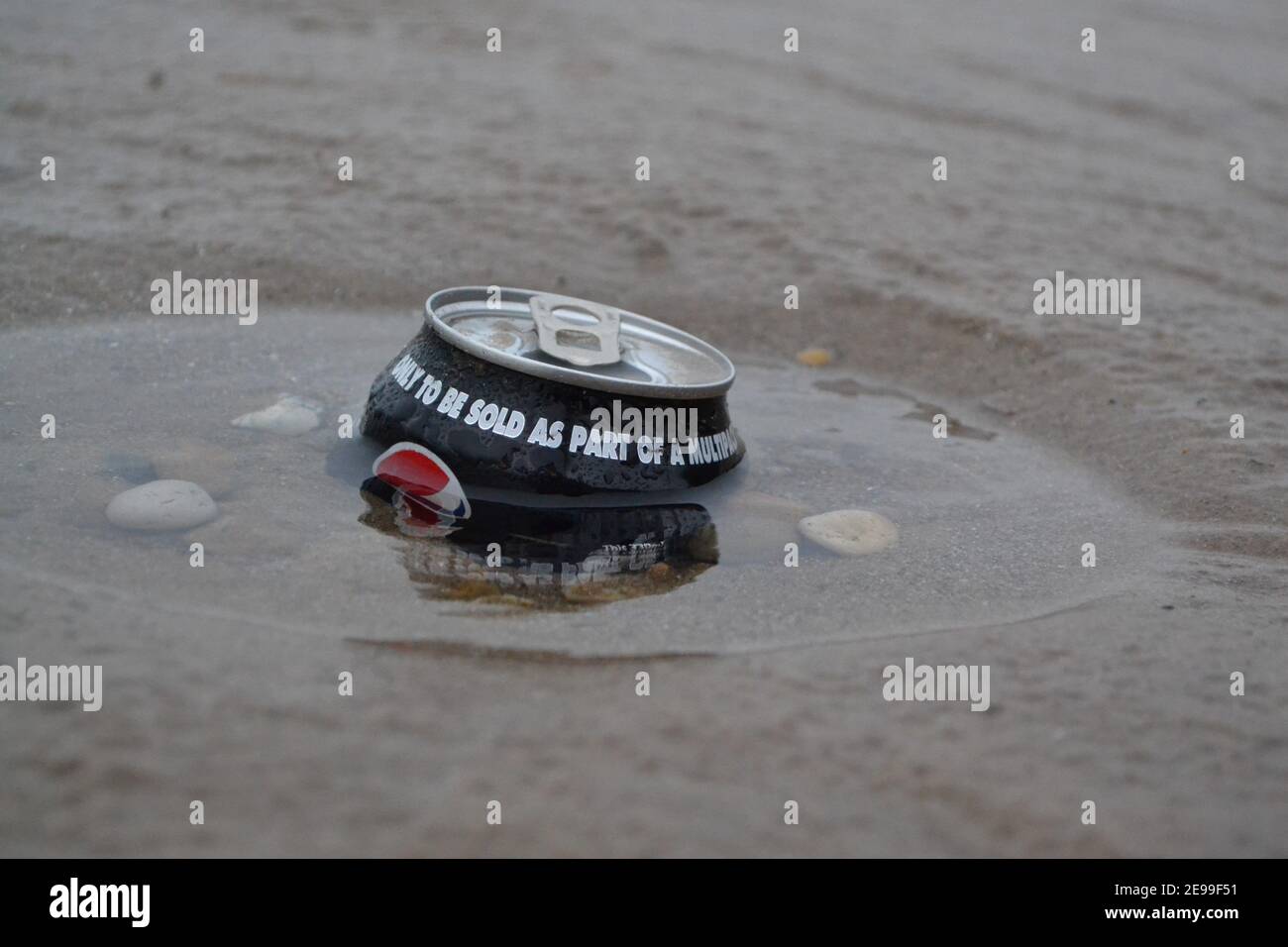 Alkoholfreie Getränke können an Einem Strand zurückgelassen werden - in den Sand geschoben - Müll - Wurf im Sand - Kieselsteine / Steine / Sand - Abfallverschmutzung - Yorkshire - Großbritannien Stockfoto