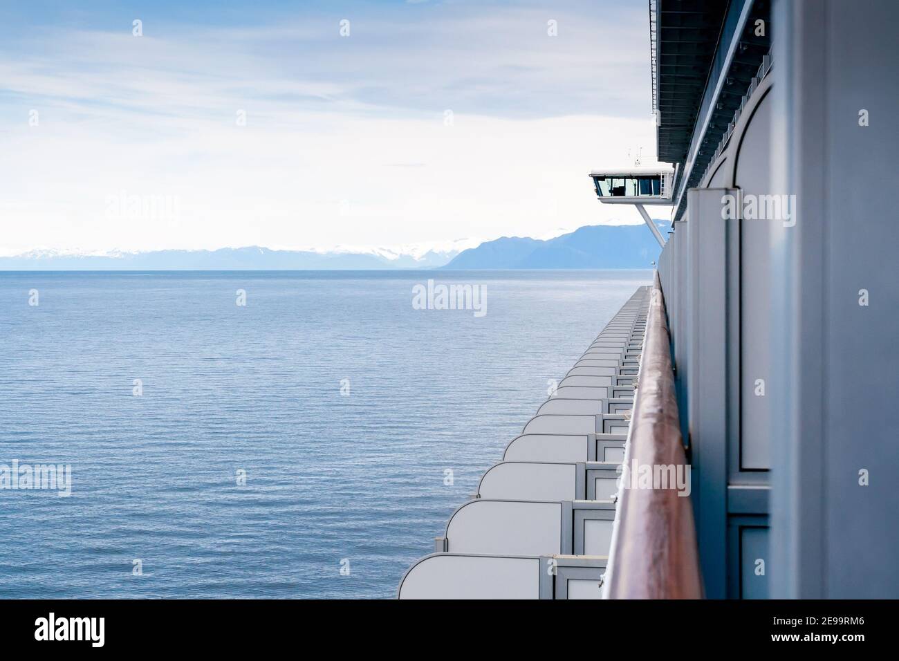 Ein Blick auf das Meer und schneebedeckte Berge entlang der Küste von Alaska, gesehen vom Balkon eines Kreuzfahrtschiffes Stockfoto