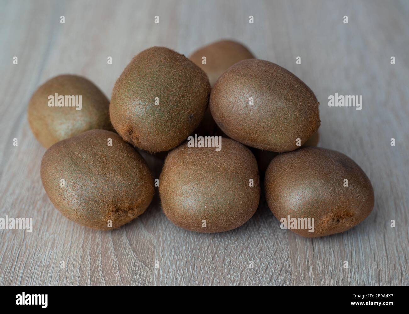 Gruppe von reifen ganzen grünen Kiwi Frucht auf einem hölzernen Tabelle Stockfoto