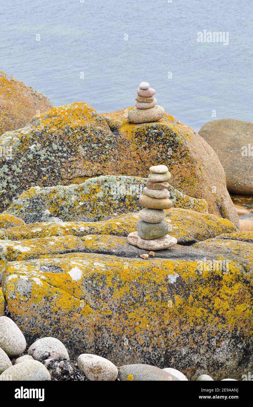 Säulen aus Kieselsteinen auf bunten Flechten bedeckt Felsen auf der Insel St. Agnes, Isles of Scilly.Cornwall.UK Stockfoto
