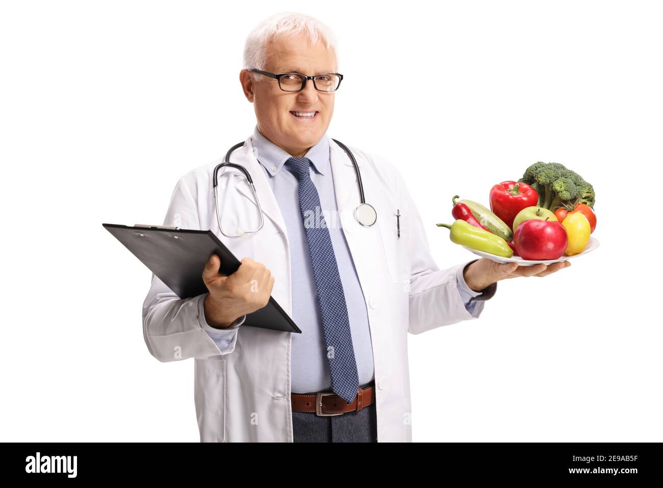 Reifen männlichen Arzt hält einen Teller mit gesunden Früchten und Gemüse isoliert auf weißem Hintergrund Stockfoto