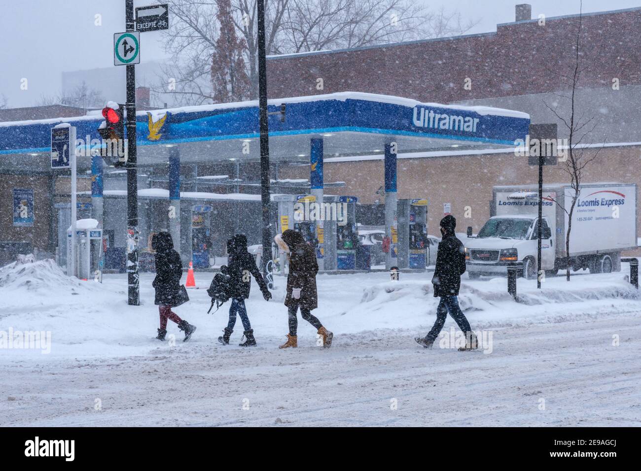 Montreal, CA - 2. Februar 2021: Menschen, die bei starkem Schneefall auf der Straße spazieren Stockfoto