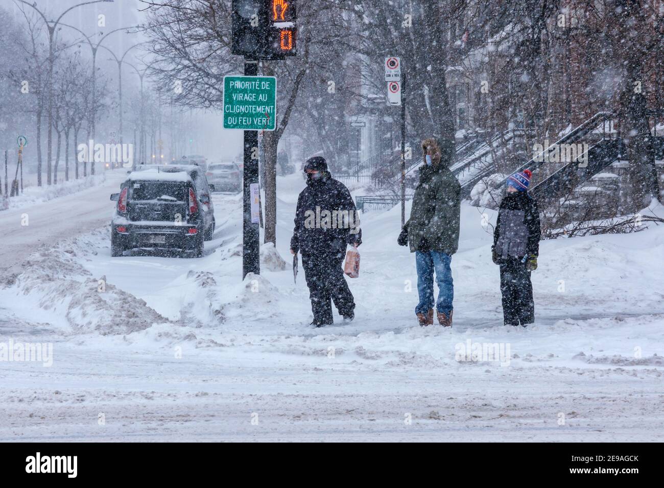 Montreal, CA - 2. Februar 2021: Menschen warten auf das Licht bei starkem Schneefall Stockfoto