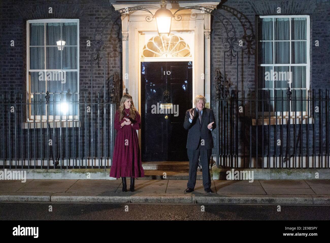 03. Februar 2021. London, Großbritannien. Der britische Premierminister Boris Johnson und seine Partnerin Carrie Symonds klatschen vor der Haustür der Downing Street 10 zu Ehren von Captain Tom Moore. Johnson hat die Bevölkerung Großbritanniens ermutigt, an einem öffentlichen Klatsch später an diesem Abend teilzunehmen, in Anerkennung des berühmten Health Service Charity Fund-Raiser Captain Tom, der am Dienstag starb. Foto von Ray Tang. Stockfoto