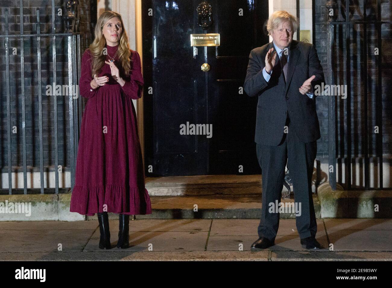 03. Februar 2021. London, Großbritannien. Der britische Premierminister Boris Johnson und seine Partnerin Carrie Symonds klatschen vor der Haustür der Downing Street 10 zu Ehren von Captain Tom Moore. Johnson hat die Bevölkerung Großbritanniens ermutigt, an einem öffentlichen Klatsch später an diesem Abend teilzunehmen, in Anerkennung des berühmten Health Service Charity Fund-Raiser Captain Tom, der am Dienstag starb. Foto von Ray Tang. Stockfoto