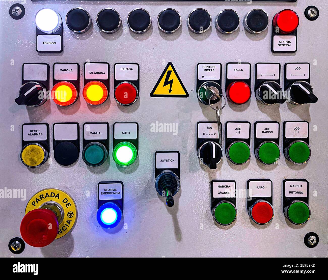 Tastenfeld des Bedienfelds einer Maschine mit verschiedenen Drucktasten und Wahlschaltern, Not-aus und farbigen Alarmleuchten, Hochspannung Stockfoto