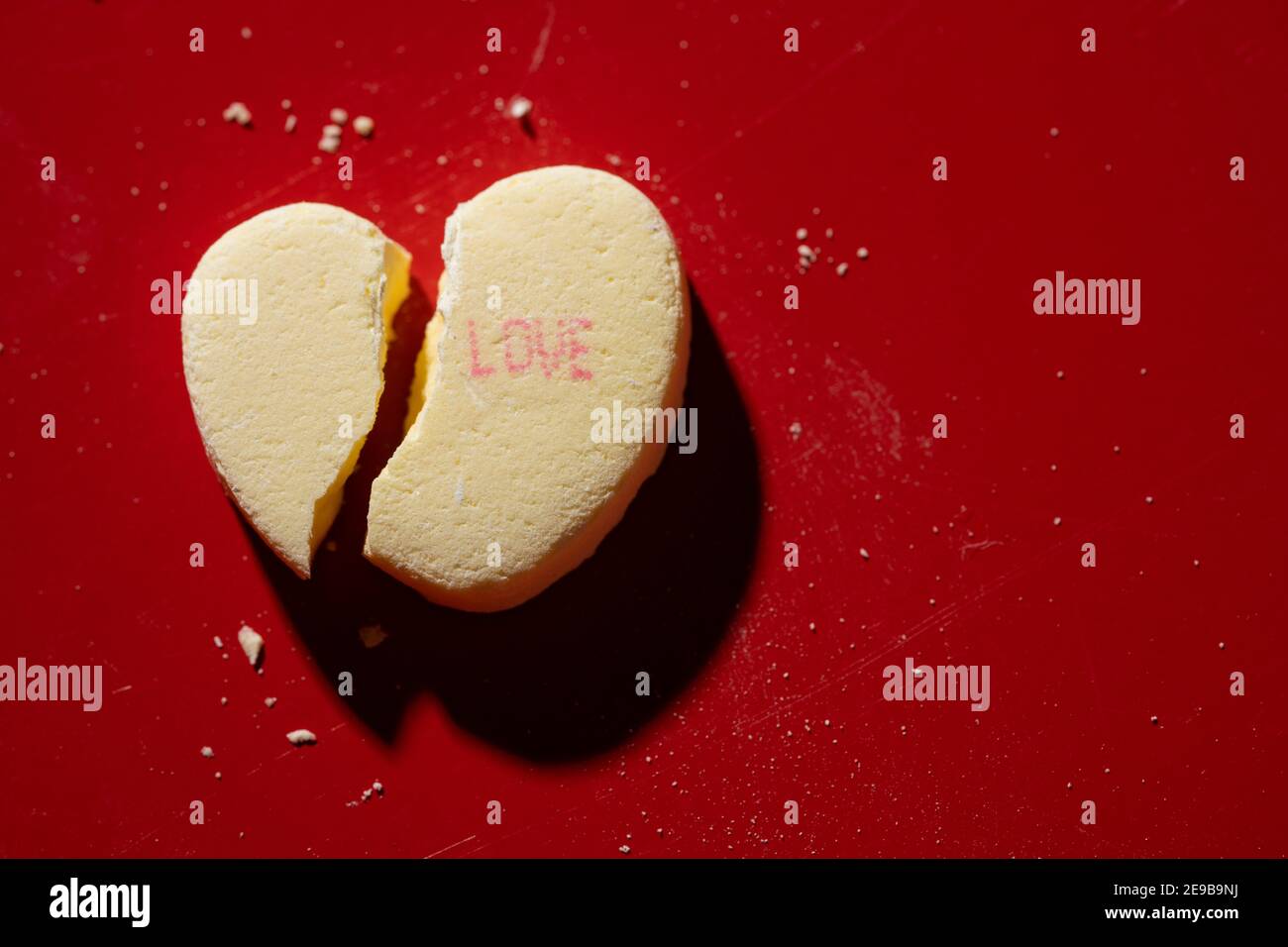 Ein zerbrochenes Candy-Gespräch-Herz mit 'Liebe' aufgedruckt Stockfoto