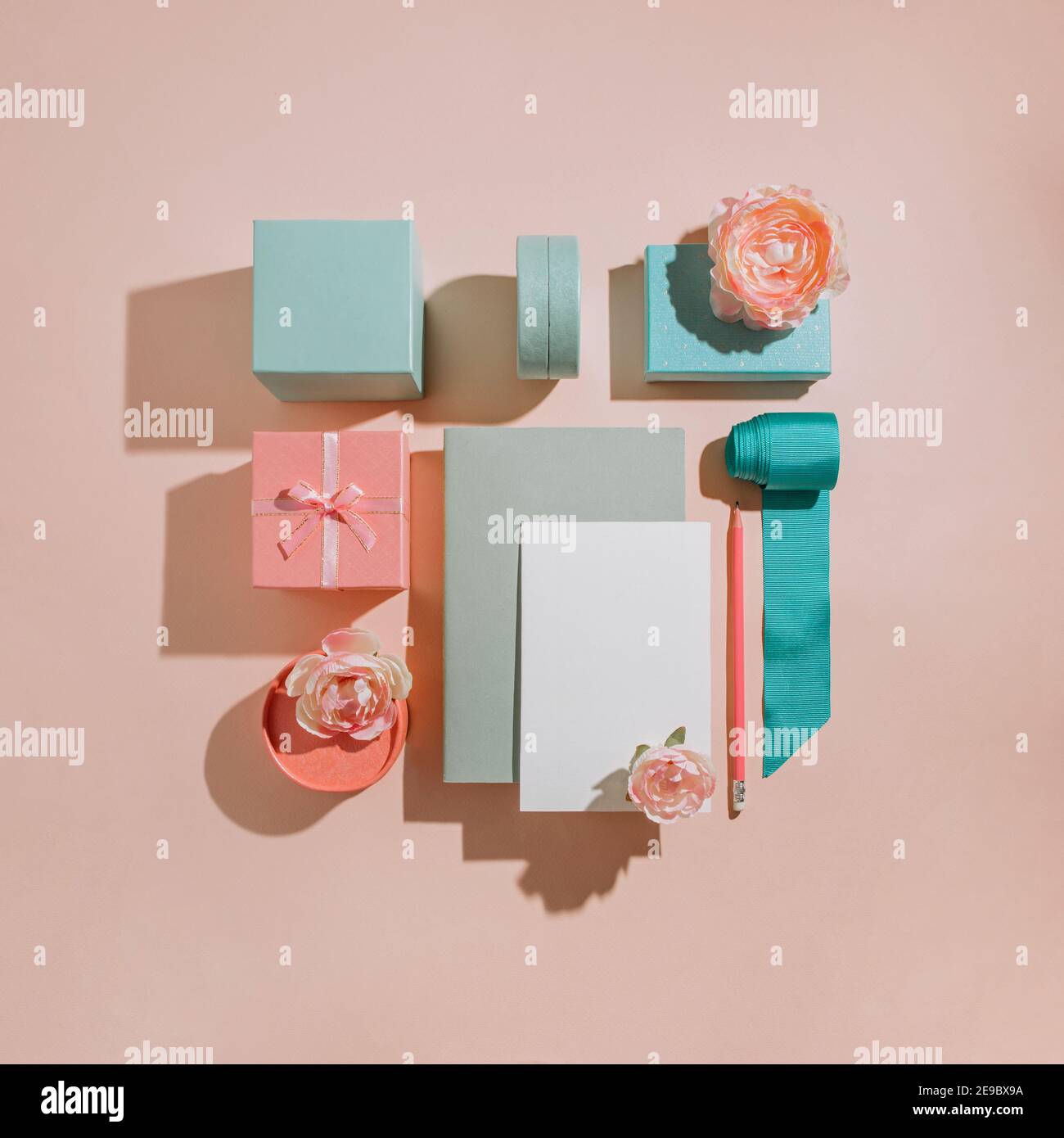 Geometrische Komposition von Geschenkschachteln mit Blumen, Mockup für Karten, Einladungen in Pastell gedämpften Farben. Romantisches Konzept Layout für Hochzeitseinladung Stockfoto