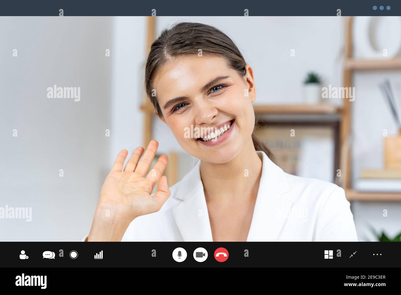 Kaukasische Frau in formellen Business-Anzug Blick auf Kamera und Winkende Hand bye bye, während die Videokonferenz für Work from Home Konzept Stockfoto
