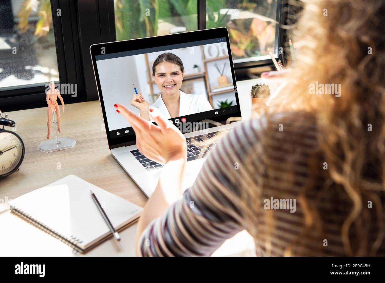 Lächelnd glücklich kaukasischen Frau in Geschäftskleidung arbeiten auf Video Telefonkonferenz mit Kollegen, die zu Hause einen Laptop verwenden Die Zeit der Pandemie Stockfoto