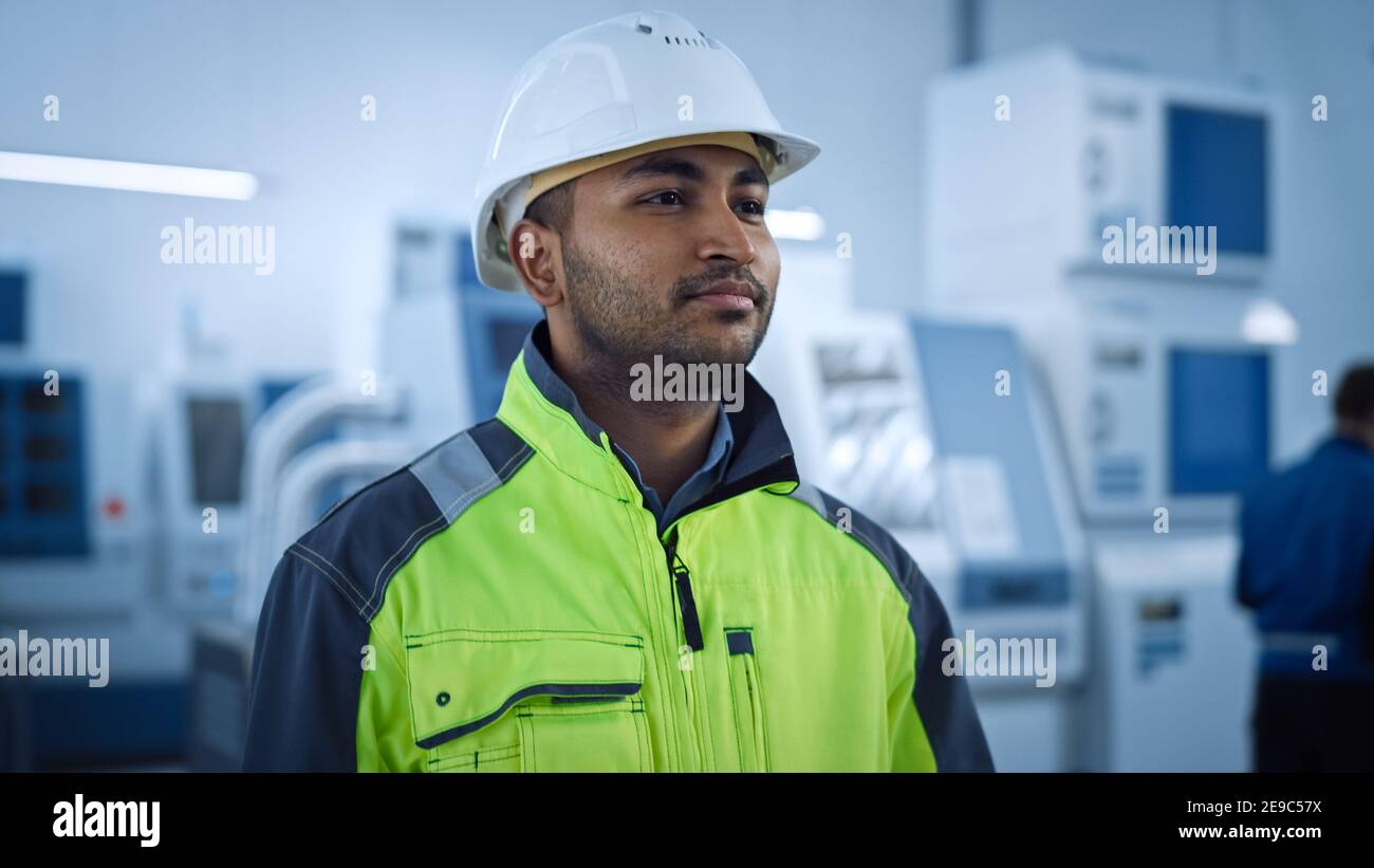 Industrie 4 Fabrik: Portrait eines modernen Arbeiters Tragen von Sicherheitsjacke und Harthut Spaziergänge durch Zeitgenössische Industrie-Workshop, wo Profis Stockfoto
