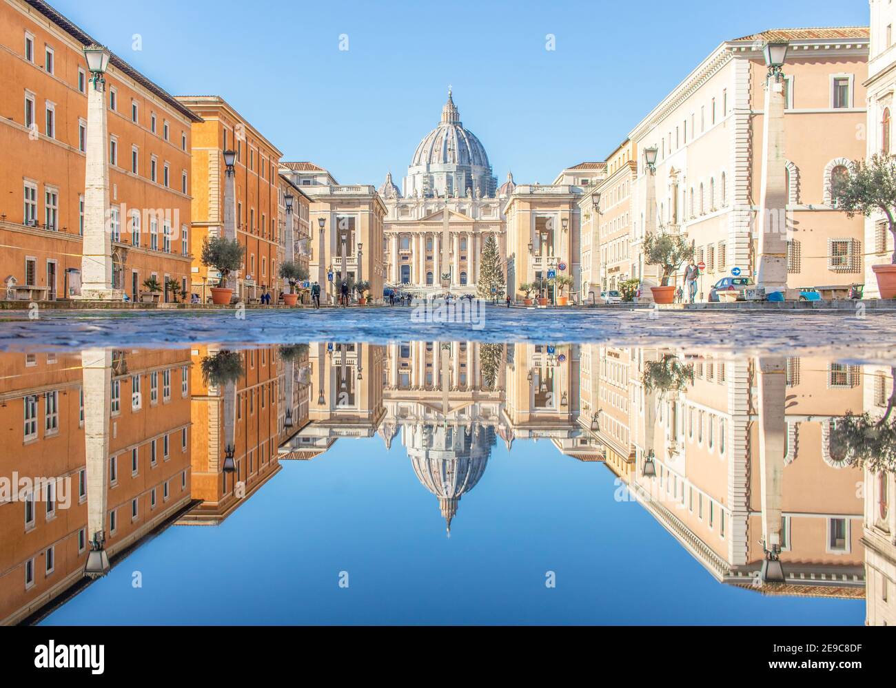 Häufige Regenschauer schaffen Pools, in denen sich die wunderbare Altstadt Roms wie in einem Spiegel spiegelt. Hier insbesondere der Petersdom Stockfoto