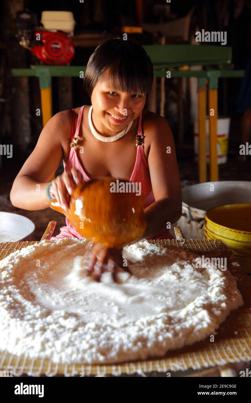 Junge indianerin, die auf traditionelle Weise das Maniokmehl zu einem Teig zubereitet, Mato Grosso, Brasilien, Süd-Amreica. Stockfoto