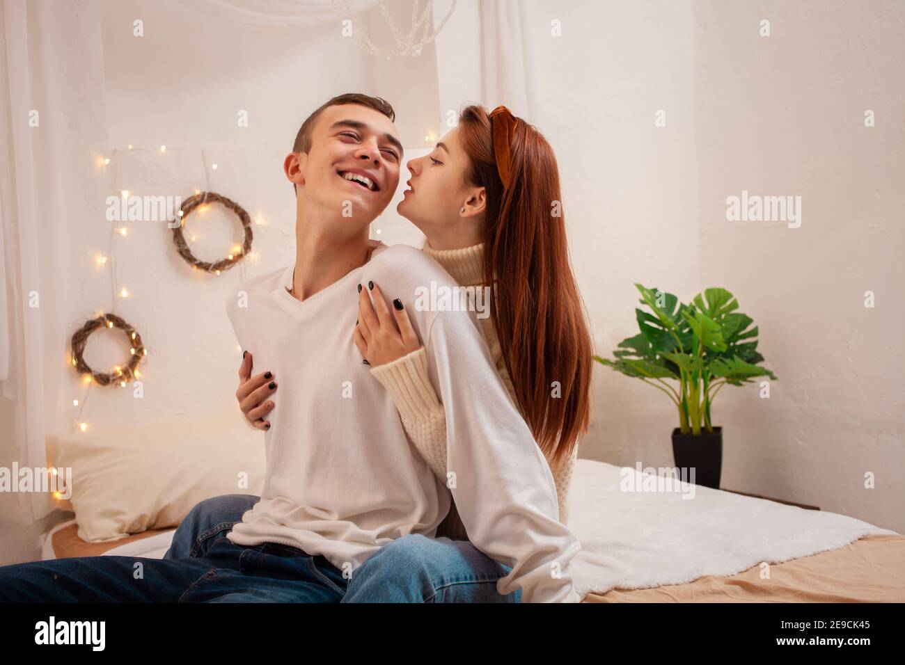 Ein junges Paar in der Liebe in einem Fotostudio. Weihnachtslandschaft, Kerl und Mädchen lieben einander. Posiert für Models im Studio am Silvesterabend. Teenager Stockfoto