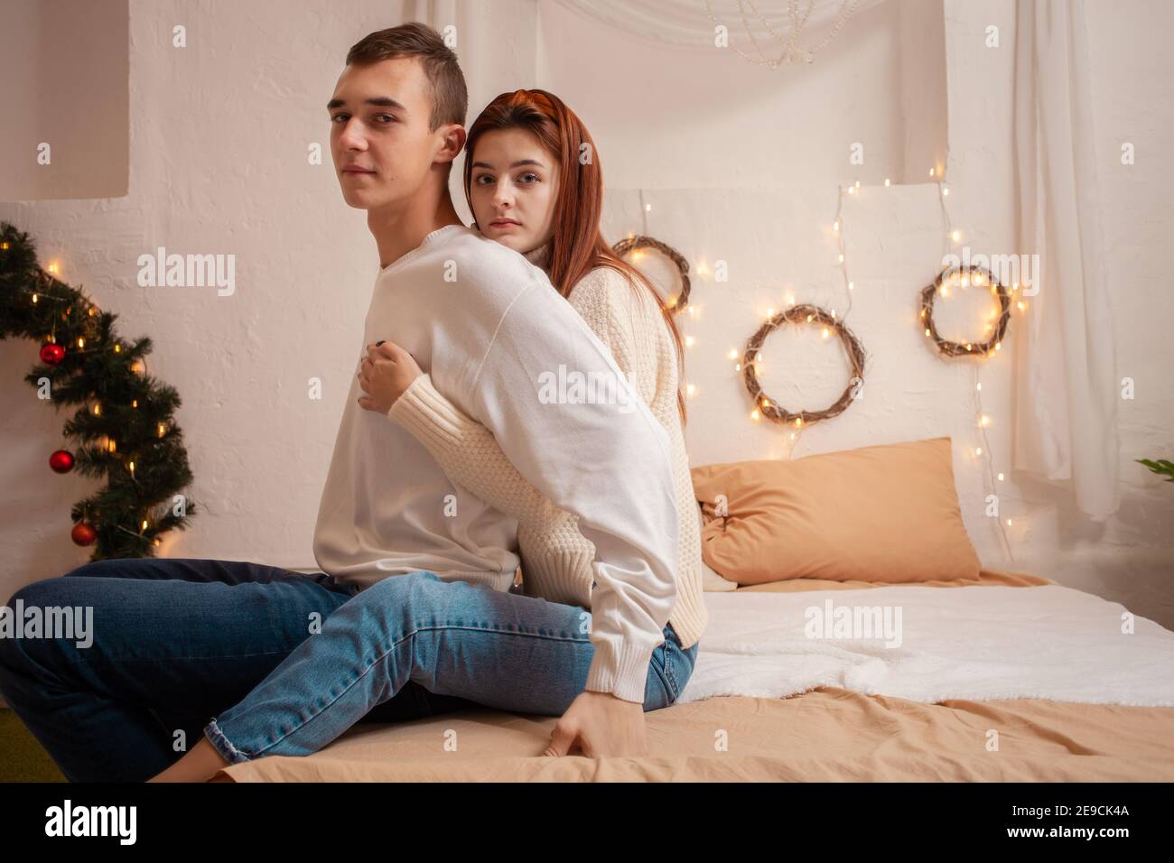 Ein junges Paar in der Liebe in einem Fotostudio. Weihnachtslandschaft, Kerl und Mädchen lieben einander. Posiert für Models im Studio am Silvesterabend. Teenager Stockfoto