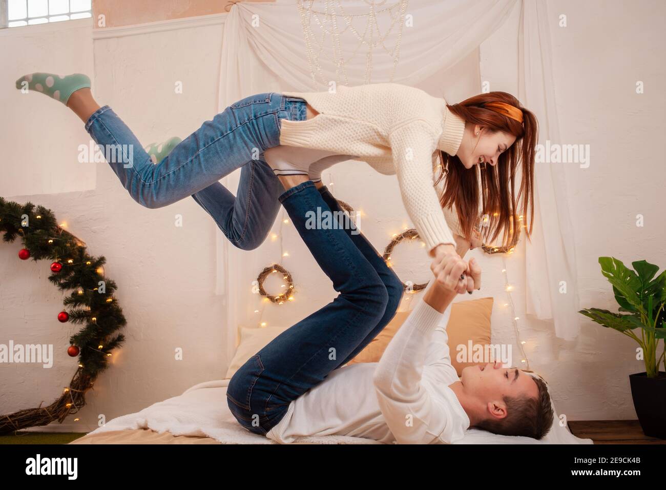 Ein junges Paar in der Liebe in einem Fotostudio. Weihnachtslandschaft, Kerl und Mädchen lieben einander. Posiert für Models im Studio am Silvesterabend. Personen p Stockfoto