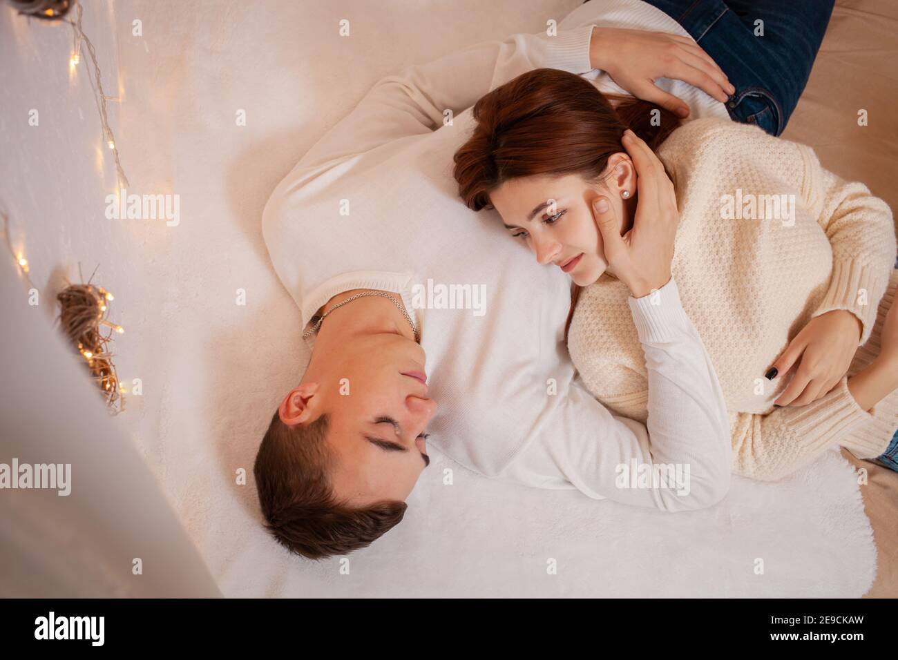 Ein junges Paar in der Liebe in einem Fotostudio. Weihnachtslandschaft, Kerl und Mädchen lieben einander. Posiert für Models im Studio am Silvesterabend. Teenager Stockfoto