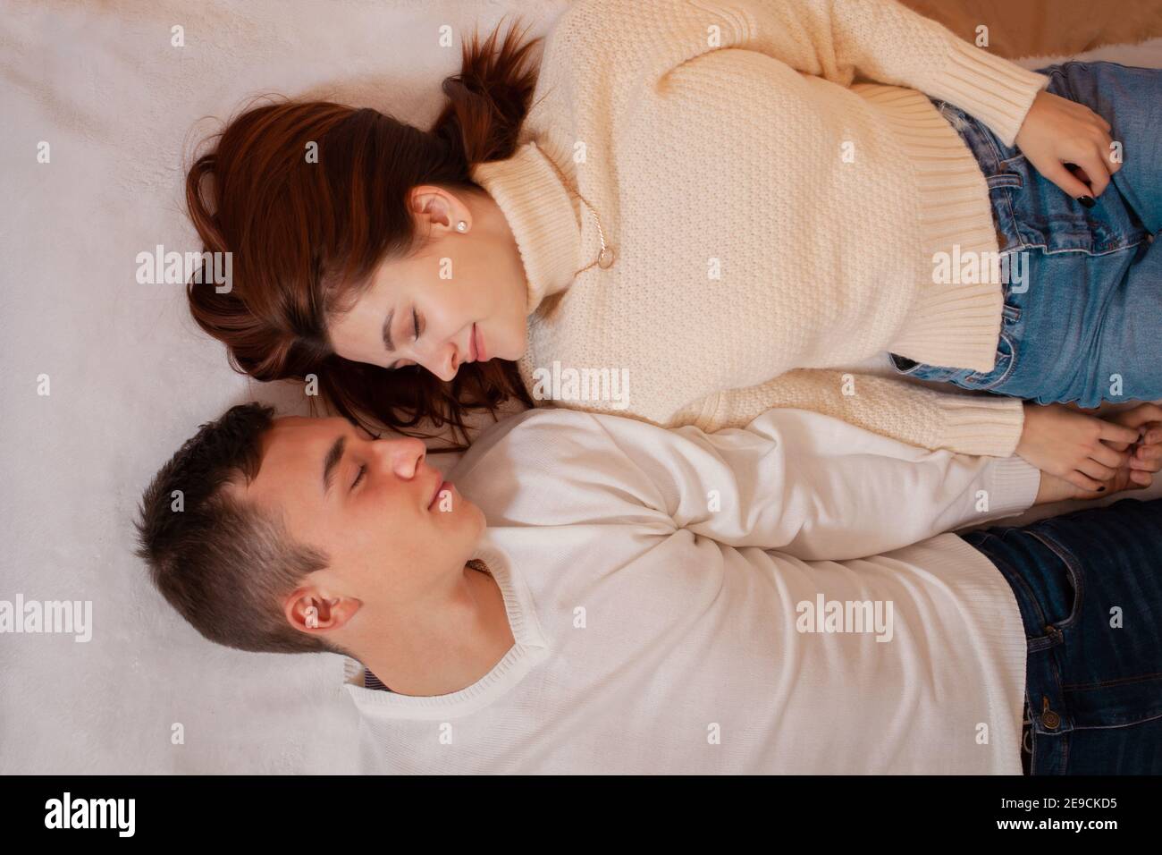 Ein junges Paar in der Liebe in einem Fotostudio. Weihnachtslandschaft, Kerl und Mädchen lieben einander. Posiert für Models im Studio am Silvesterabend. Teenager Stockfoto