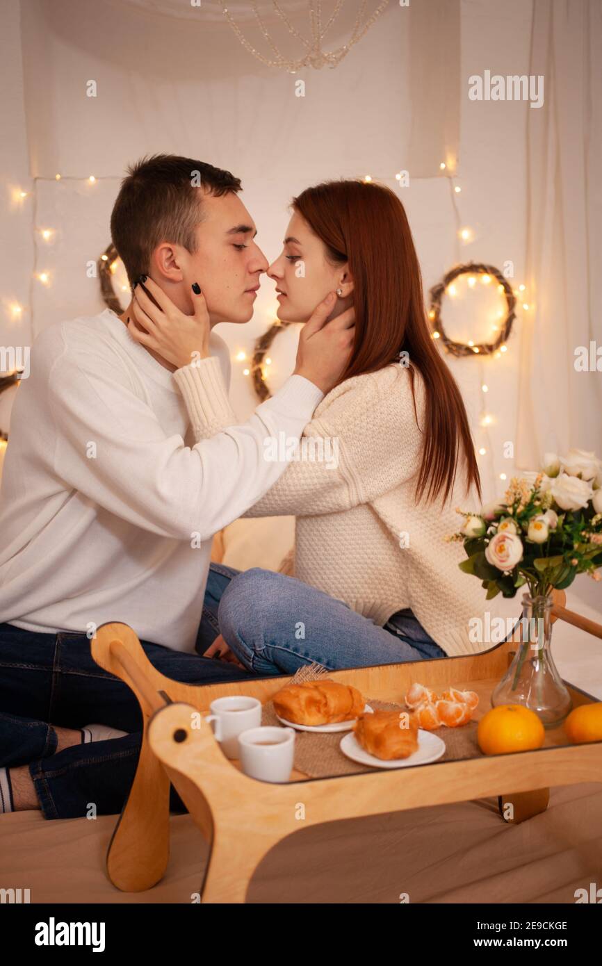 Ein junges Paar in der Liebe in einem Fotostudio. Weihnachtslandschaft, Kerl und Mädchen lieben einander. Posiert für Models im Studio am Silvesterabend. Teenager Stockfoto