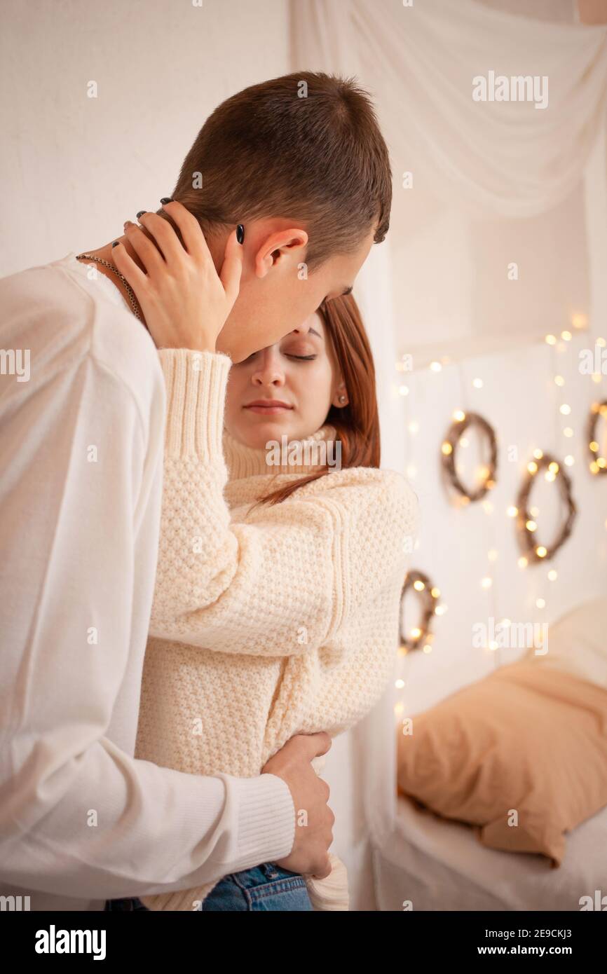 Ein junges Paar in der Liebe in einem Fotostudio. Weihnachtslandschaft, Kerl und Mädchen lieben einander. Posiert für Models im Studio am Silvesterabend. Teenager Stockfoto