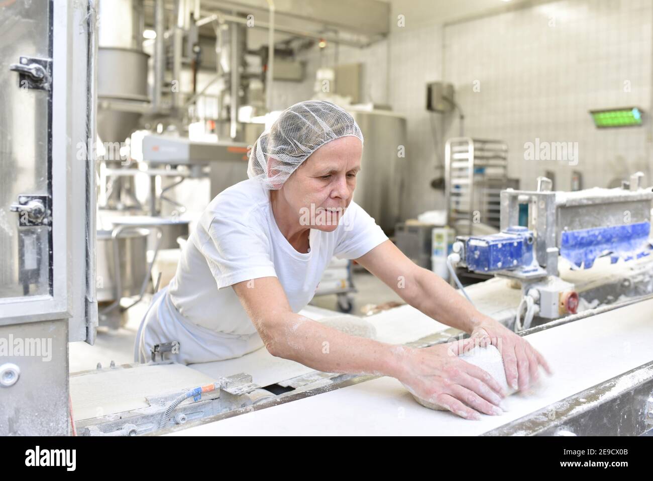 Arbeiter in einer Großbäckerei - Industrieproduktion von Backwaren auf einer Fließstrecke Stockfoto