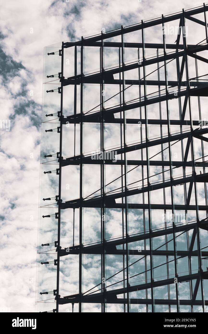 Moderne symmetrische Architektur, alle Glas-und Stahlfassade Dreieck mit einem blauen und Wolkenhimmel im Hintergrund geformt Stockfoto Moderne symmetrische Architektur, alle Glas-und Stahlfassade Dreieck mit einem blauen und Wolkenhimmel im Hintergrund geformt Stockfoto