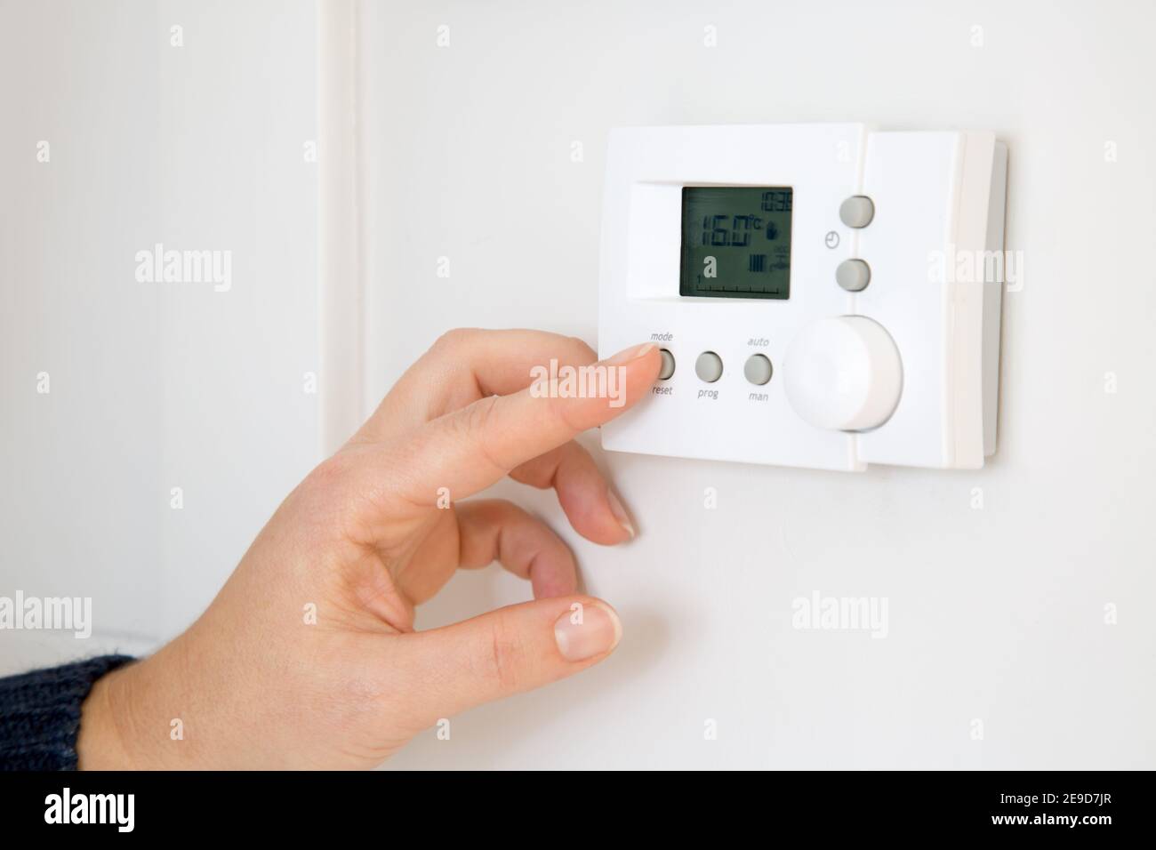 Frau Hand Einstellung digitale Zentralheizung Thermostat zu Hause Stockfoto