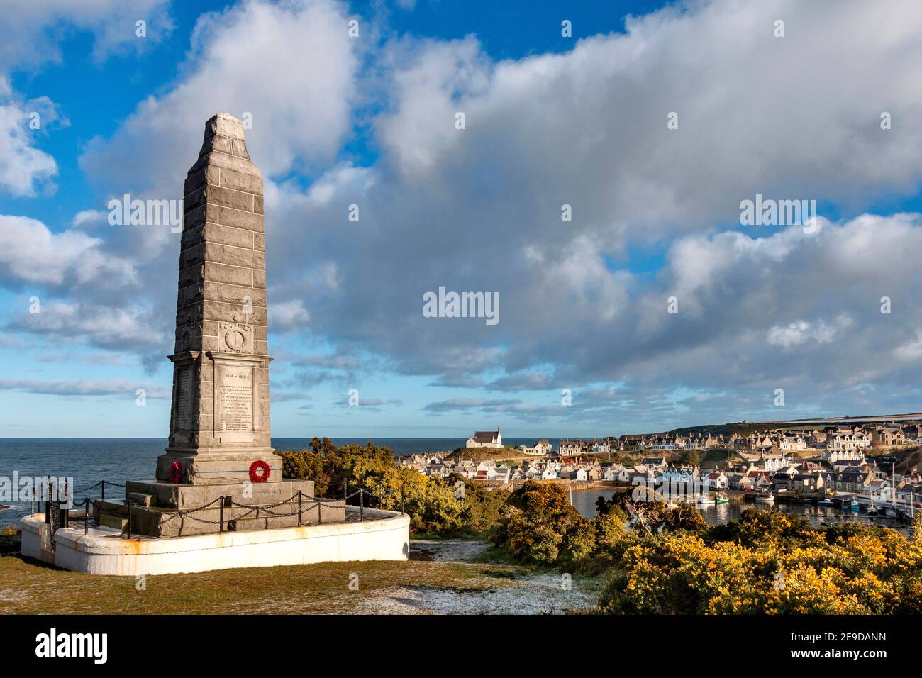 FINDOCHTY MORAY COAST SCOTLAND IMPOSANTES KRIEGSDENKMAL MIT BLICK AUF DEN HAFEN AN EINEM FROSTIGEN MORGEN EINE WEISSE KIRCHE AUF DEM HÜGEL Stockfoto