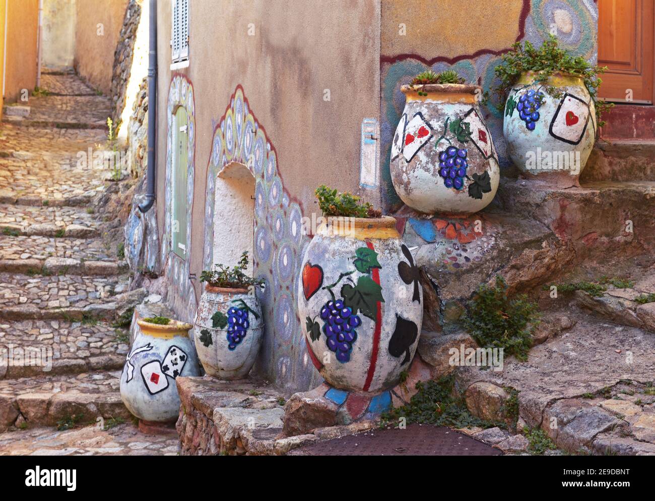 Blumenkübel mit Spielkarten und Trauben in einer Gasse gemalt, Frankreich, Korsika, Speluncato Stockfoto