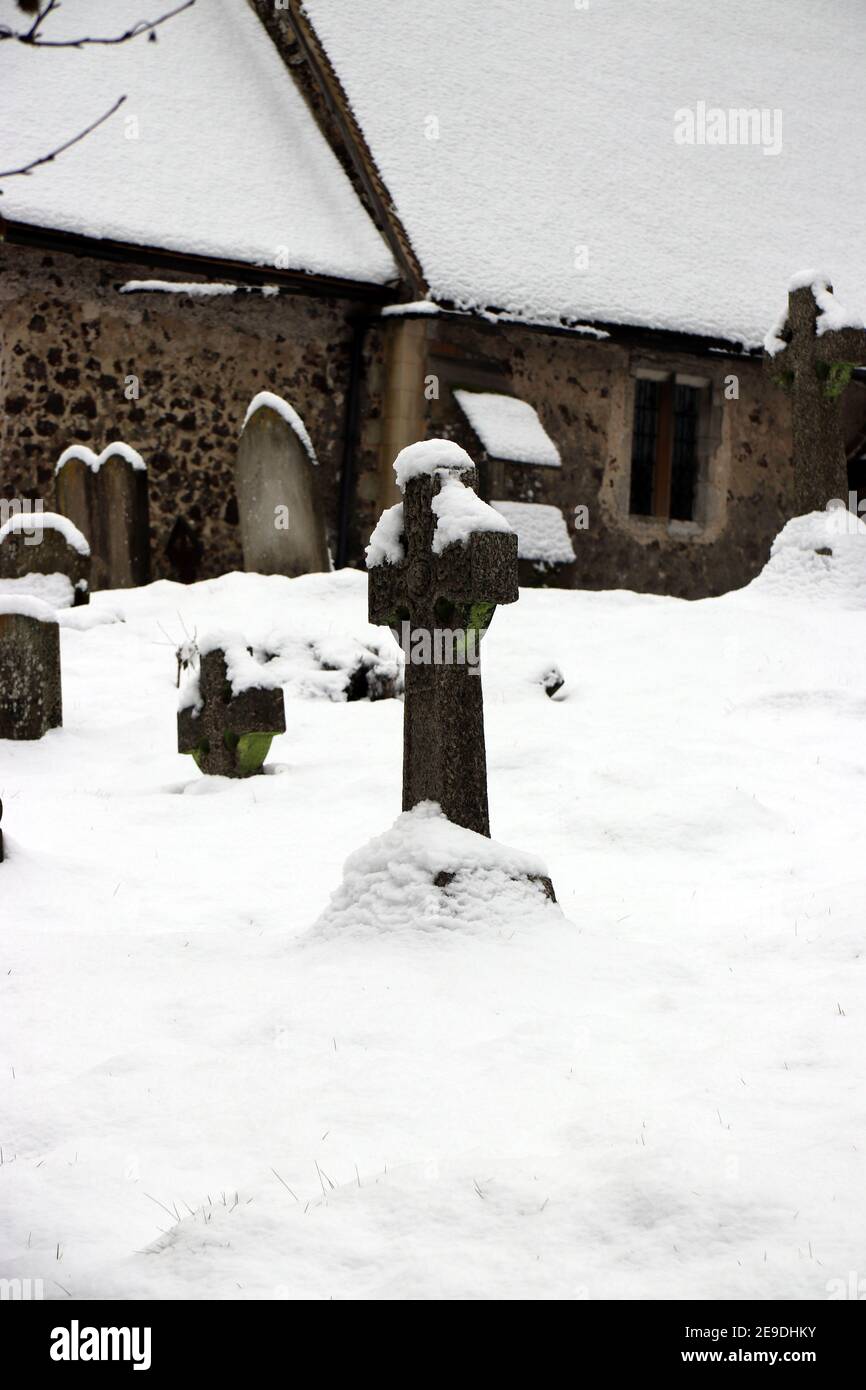 Kirche und Kirchhof von St. Nicholas, Pyrford, Surrey, im Winter in Großbritannien im Schnee Stockfoto