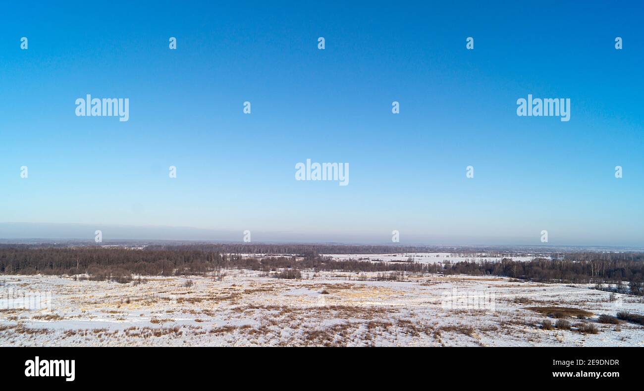 Die Winterlandschaft mit schlichtem, blauem Himmel auf dem Hintergrund. Schöne Art mit Horizont an Land in Russland Stockfoto