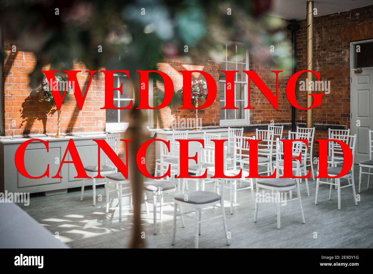 Hochzeit abgesagt wegen Covid 19 Pandemie Sperrbeschränkungen rot Text und Bild des Trauungsraumes hinter leer schreiben Stühle keine Gäste Stockfoto