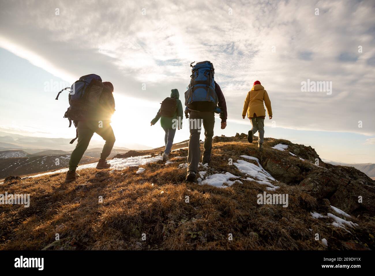 Gruppe von vier Wanderern mit Rucksäcken Spaziergänge in den Bergen an Sonnenuntergang Stockfoto