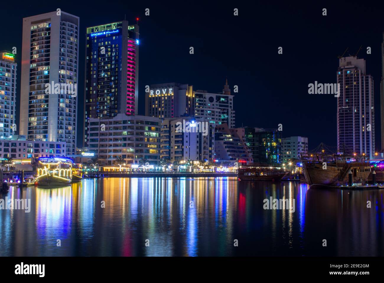 'Dubai, Dubai/Vereinigte Arabische Emirate - 10/30/2020: Dubai Marina Yacht Club und Rove Hotel Langzeitbelichtung Panorama in der Nacht mit Lichtern der Skyline und cr Stockfoto