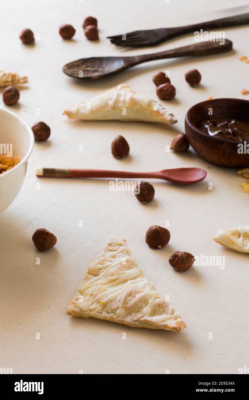 Einige Nutella Handgebäck mit einem Holzlöffel und einige Haselnuss auf weißem Hintergrund Stockfoto