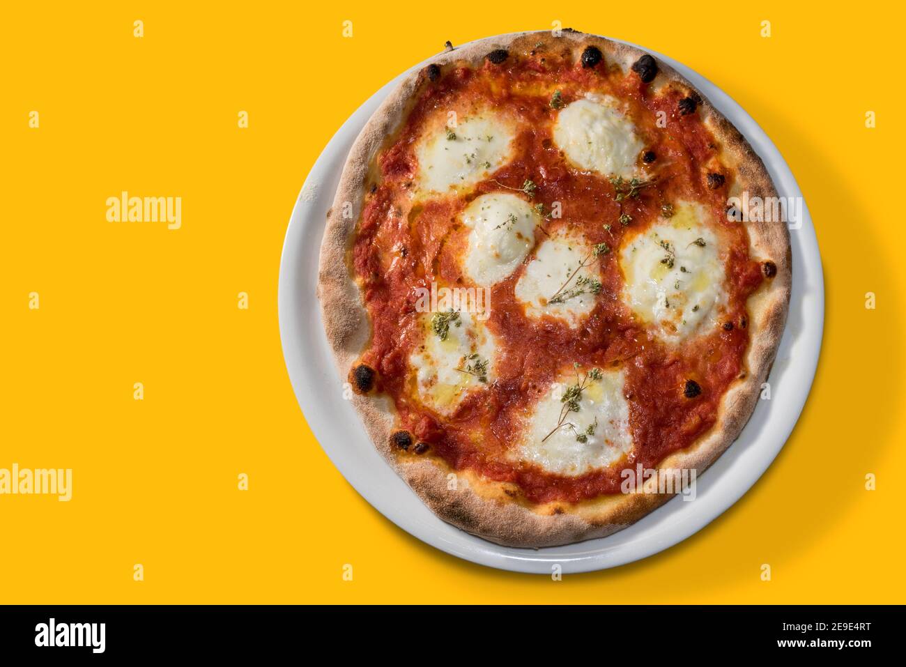 Pizza mit Tomatensauce und Mozzarella Käse und Oregano in Weiße Platte isoliert auf gelbem Hintergrund.flache Lage in Draufsicht Mit Kopierbereich Stockfoto